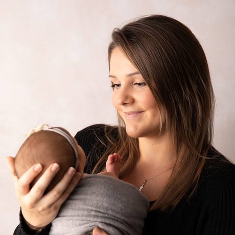Natascha, Fotografin des Ateliers, mit einem Baby auf dem Arm